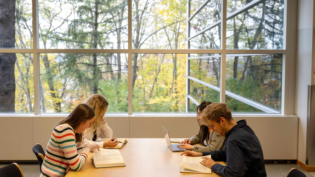 Four students studying at a table on the second floor of the Law Library