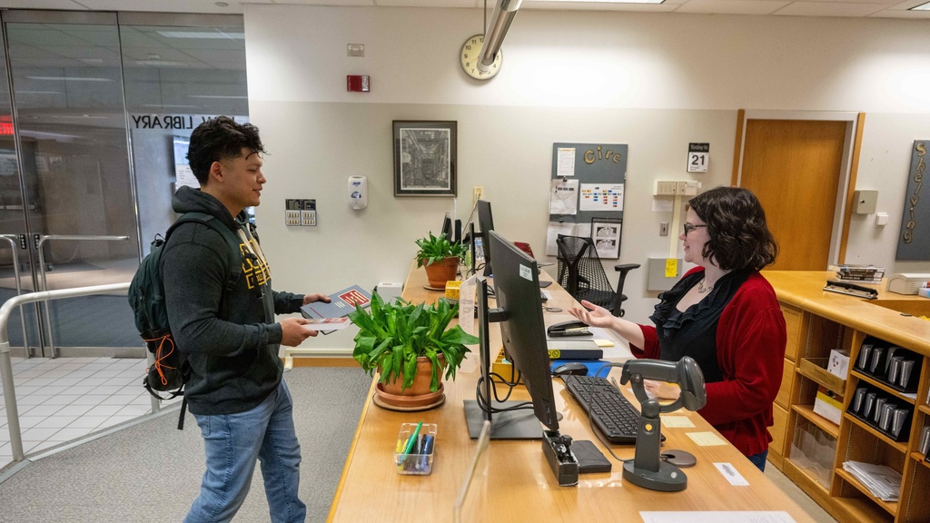 A student receiving assistance at the Law Library circulation desk